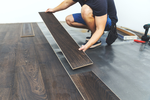 A local flooring installer installing vynl plank flooring