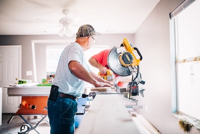 A local handyman repairing a door for a client.